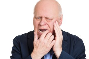 bald elderly man with tooth pain